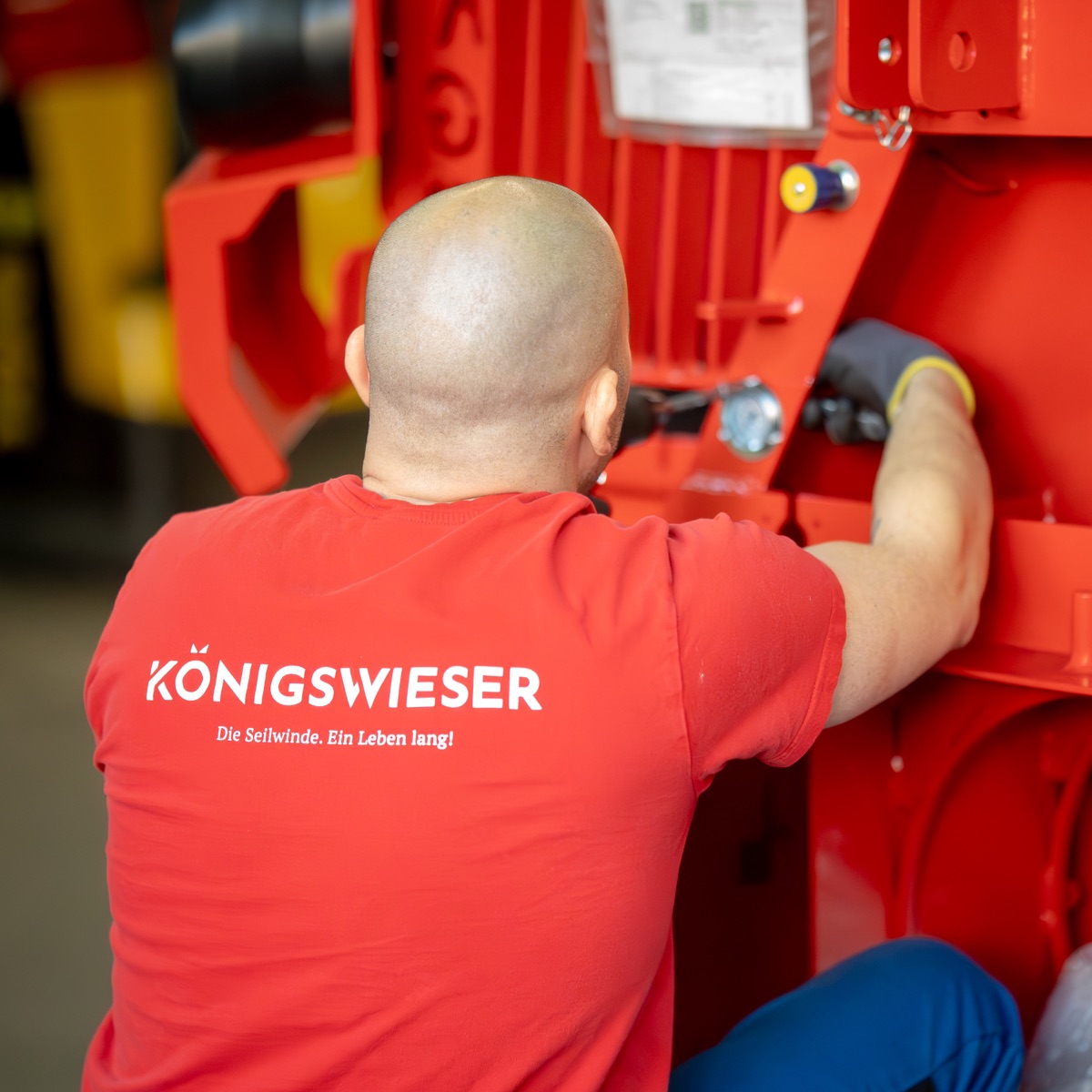 Königswieser-Mitarbeiter an einer Forstseilwinde in der Werkstatt Vorchdorf